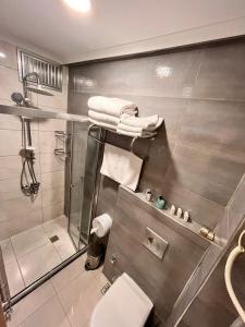 a bathroom with a shower and a toilet and towels at Şimal Hotel in Rize