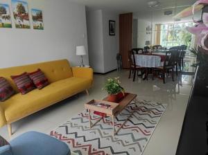 a living room with a yellow couch and a table at Departamento de Isa in Cajamarca