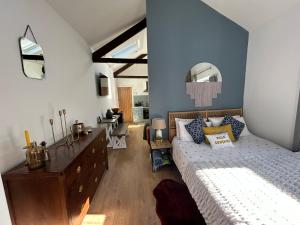 a bedroom with a bed and a dresser in a room at Heart of Falmouth - Entire Studio Apartment in Falmouth