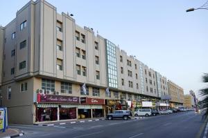 a large building on a city street with cars parked in front at شقق منصور بلازا للشقق المخدومة in Dammam