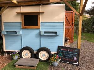 a tiny house with a sign in front of it at Strawberry Fields Glamping at Cottrell Family Farm in Wokingham