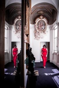 a woman standing in a hallway in front of a mirror at Eitch Borromini Palazzo Pamphilj in Rome