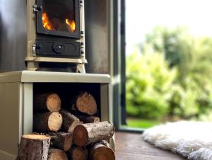 a pile of logs sitting in a stove at Romantic Retreat - Luxury Shepherds Hut + Hot Tub! in Camborne
