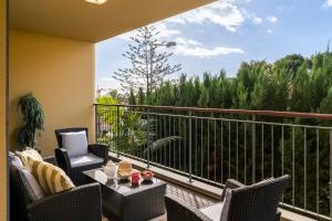 einen Balkon mit Stühlen und einem Tisch mit Aussicht in der Unterkunft Comboio I by An Island Apart in Funchal