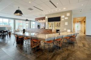 un restaurant avec un bar doté de tables et de chaises dans l'établissement Courtyard by Marriott North Brunswick, à North Brunswick