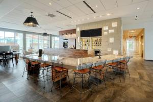 a restaurant with a bar with tables and chairs at Courtyard by Marriott North Brunswick in North Brunswick