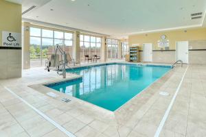 a pool with blue water in a building at Courtyard by Marriott North Brunswick in North Brunswick