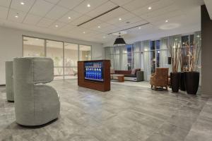 a lobby with a television in the middle of a room at Courtyard by Marriott North Brunswick in North Brunswick