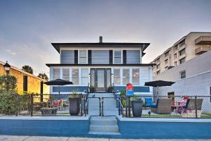 a blue house with chairs and umbrellas in front of it at Downtown Daytona Beach Home Walk to Halifax River in Daytona Beach