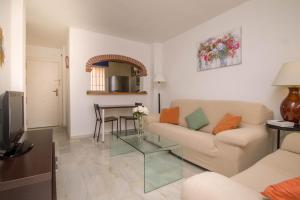 een woonkamer met een bank en een tafel bij Erisa 56 By IVI Real Estate in Torremolinos