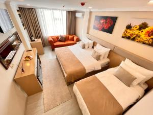 ein Hotelzimmer mit zwei Betten und einem Wohnzimmer in der Unterkunft Şimal Hotel in Rize