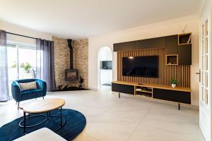 sala de estar con TV, sofá y mesa en Casa beira mar Algarve, en Albufeira