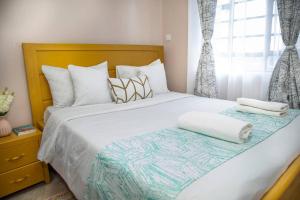 1 dormitorio con 1 cama grande y 2 toallas. en Lovely 1-bedroom apartment with free parking, en Nairobi