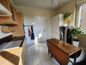 a kitchen with a wooden table and a refrigerator at Mont Naïa in Pontorson