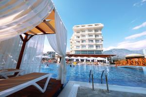 a swimming pool with a hotel in the background at Sey Beach Hotel & Spa in Alanya