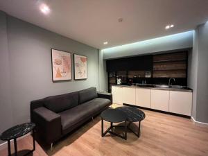 ein Wohnzimmer mit einem Sofa und einer Küche in der Unterkunft Tirana Apartments in Tirana