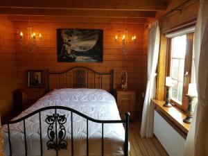 ein Schlafzimmer mit einem Bett in einem Holzhaus in der Unterkunft Romantisch Huisje nabij het strand in Julianadorp