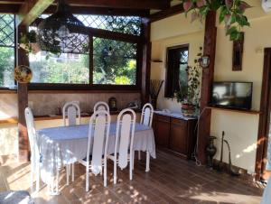 a dining room with a table and white chairs at B&B Angolo Verde in Terni