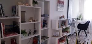 een woonkamer met witte planken met boeken bij Casa Lola in Cavallino-Treporti