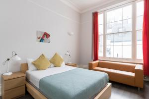 1 dormitorio con cama, sofá y ventana en Stay Hyde Park, en Londres
