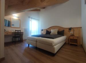a bedroom with a bed and a desk and a table at Eco-Baita Natura Spensierata in Canale San Bovo