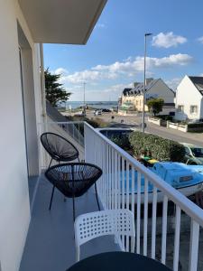 een balkon met 2 stoelen en uitzicht op de oceaan bij Beau studio à 150 m de la plage in Ploemeur