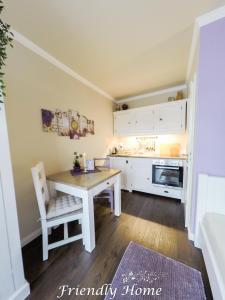 una cucina con tavolo e una cucina con armadietti bianchi di Friendly Home - Doppelappartement "Purple" Köln Bonn Phantasialand a Brenig