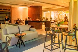 a lobby with a couch and tables and a bar at Conforto no melhor do Marista & Goiânia in Goiânia