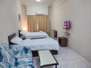 a hotel room with two beds and a couch at Sofea Inn Bukit Merah - Laketown D6529 in Kampong Selemat