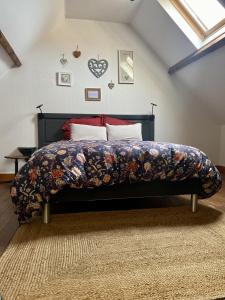 a bedroom with a bed with a floral bedspread at Les Volets Bleus in Saint-Valery-sur-Somme