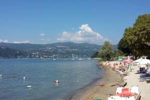 una playa con un montón de gente nadando en el agua en Casa Dolce Casa _ a due passi dal Lago Maggiore, en Angera