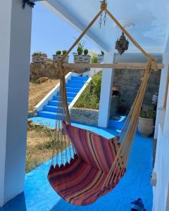 a hammock hanging from a porch with blue floor at Sanae house 