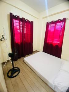 a bedroom with red curtains and a bed and a camera at SAN JOSE DEL MONTE BULACAN GUMAOK West,Delgados Place UNIT 2 in Mangangpico