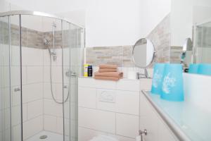 a white bathroom with a shower and a mirror at Pension Gästehaus La Mula in Treis-Karden