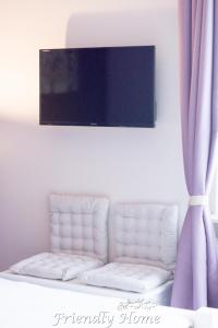 a flat screen tv on a wall above a couch at Friendly Home - Doppelappartement "Purple" Köln Bonn Phantasialand in Brenig
