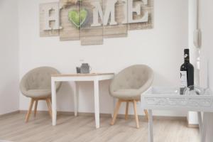 a dining room table with two chairs and a wine bottle at Pension Gästehaus La Mula in Treis-Karden +20 photos