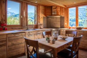 a kitchen with a wooden table and some windows at Chalet Cashmere Spirit - OVO Network in Manigod