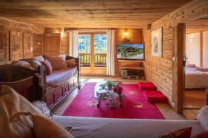 a living room with a couch and a tv in a cabin at Chalet Cashmere Spirit - OVO Network in Manigod