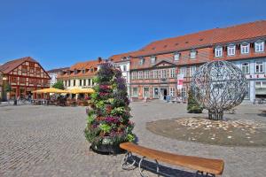 Kolonie EcktanneにあるFerienhaus Waren SEE 8221の二重のクリスマスの木とベンチのある町の広場