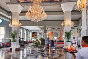un vestíbulo de un hotel con lámparas de araña y mesas en Riu Palace Riviera Maya - All Inclusive en Playa del Carmen