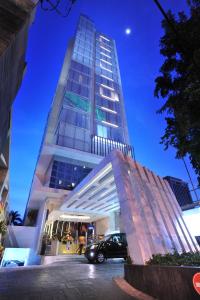 a car parked in front of a tall building at Midtown Hotel Surabaya in Surabaya