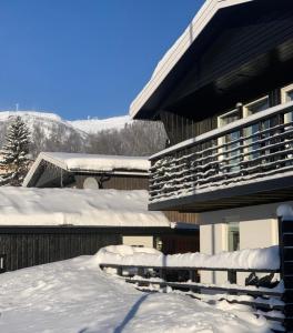 uma casa coberta de neve ao lado de uma casa em Åre Travel - Villa Solbringen eller Lilla Sol em Åre