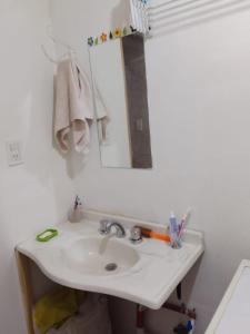 y baño con lavabo blanco y espejo. en Graciela Chacras Pueyrredón en Luján de Cuyo