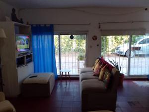 uma sala de estar com um sofá e uma televisão em Graciela Chacras Pueyrredón em Ciudad Lujan de Cuyo