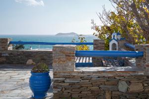 a stone wall with a blue pipe and a bench at Nataly's Apartments in Gavrio