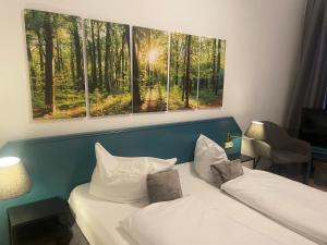 a hotel room with two beds and two paintings on the wall at Berghotel HARZ in Hahnenklee-Bockswiese