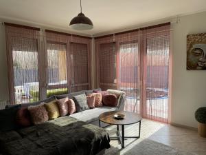 salon z kanapą i stołem w obiekcie Zen Garden Vendégház Siófok w Siófoku
