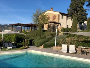 a swimming pool in front of a house at Agriturismo Casetta I in Vinci