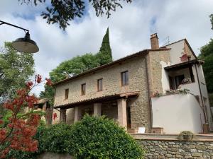 un antiguo edificio de piedra con un árbol en el fondo en Gea - In Parulia Country House, en Arezzo