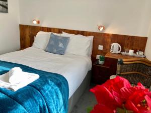 a bedroom with a bed with a blue blanket at Jersey Villa Guest House in Warwick